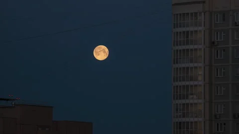 Full moon hiding behind the high-rise building on a sunrise Stock Footage 166321121