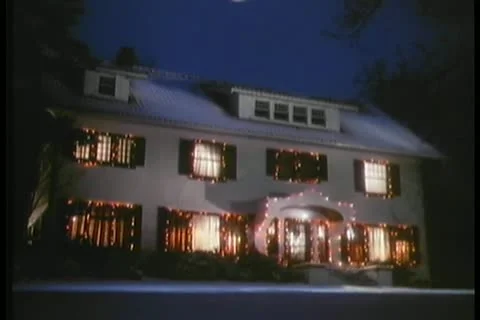 Full moon hovering over house decorated in Christmas lights Stock Footage