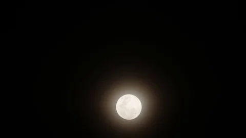 The full moon moves through the black sky in small clouds. Time laps. HD Vídeo Stock 90840622
