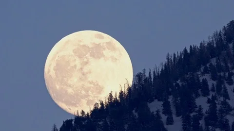 Full moon moving up mountainside at dusk Vídeo Stock 122580754
