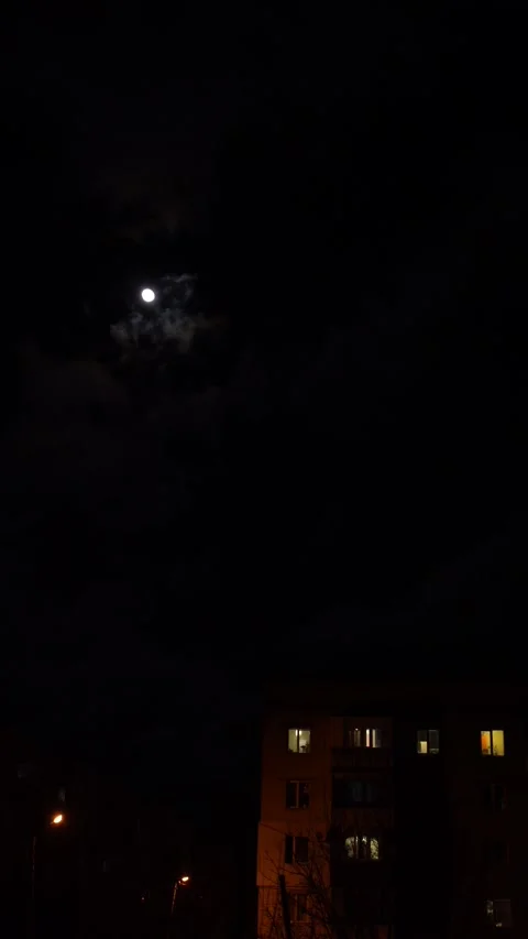 Full moon in the night sky above high-rise buildings illuminated by lanterns Stock Footage 296597334