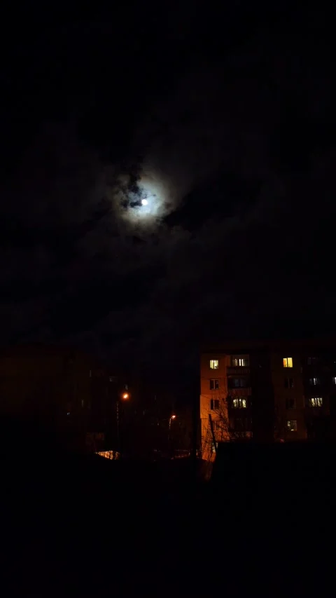 Full moon in the night sky above high-rise buildings illuminated by lanterns Stock Footage 296597365