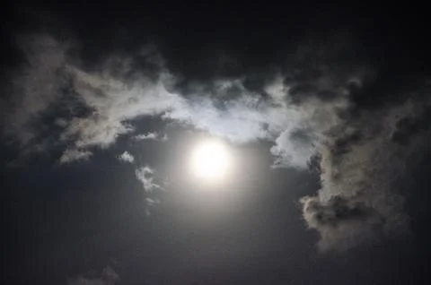 Full moon in the night sky with clouds and rays of light. Stock Photos