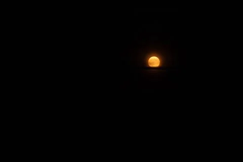 A full moon in the night sky with a dark background. Stock Photos