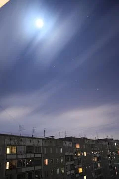 Full moon in the night sky over residential apartment building Fotos Stock