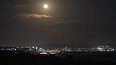 Full moon over sea and night city. Moon over town lights and water Video stock 312807788