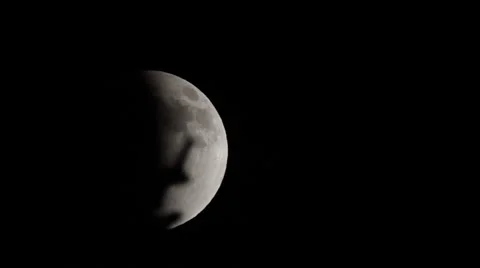 Full moon in partial eclipse slides past branches Vídeo Stock 68064665