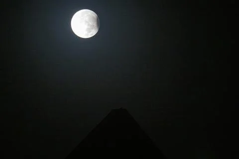 Full moon with a partial lunar eclipse behind Giza pyramids, Egypt - 18 Sep 2024 Stock Photos