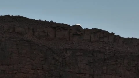 Full Moon Peeking Over Rugged Textured Desert Cliff Stock Footage 336025511