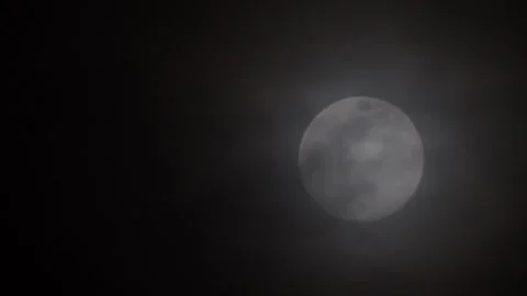 Full moon on the right of the frame with dark clouds passing across Video stock 341664517