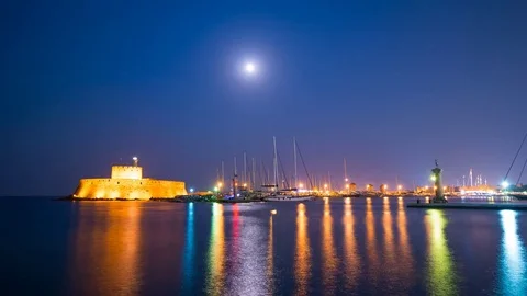 Full moon rise over St. Nicolas castle, in Mandraki marina in Rhodes island. Stock Footage