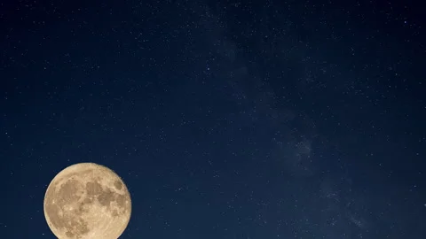 The full moon rises against the background of a beautiful starry sky with Stock Footage 243976245