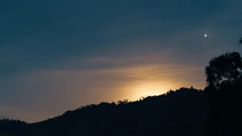 Full moon rises from behind the mountain. 4K time-lapse Stock Footage 162400760