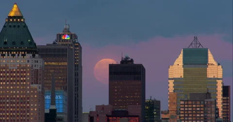 Full moon rises behind New York City skyscrapers on a clear night. Stock Footage 67243945