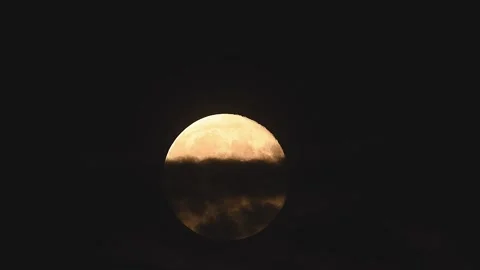 Full moon rises dramatically through clouds in a stunning 4k time lapse Stock Footage 305431027