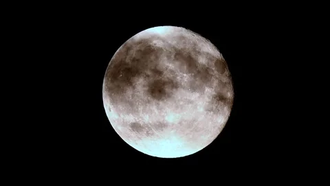 Full moon rises majestically through clouds over a dark night sky in stunning 4k Stock Footage 305430762