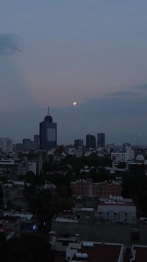 Full moon rises over Mexico City at sunset in autumn zoom in camera mZoom Luna V Stock Footage 289569672