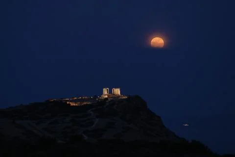 Full moon rises over temple of Poseidon in Cape Sounio, Sounion, Greece - 12 May Stock Photos