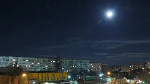Full moon rises over top of old communist era buildings, at night. Stock Footage 296387098