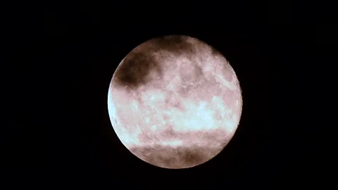 Full moon rises through clouds in cinematic time lapse under the dark night sky Stock Footage 305430254
