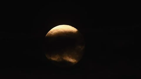 Full moon rises through clouds illuminating the dark sky in a breathtaking Stock Footage 305430309