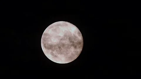 Full moon rises through dark clouds in stunning cinematic time lapse Stock Footage 303610586