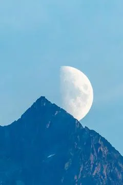 Full Moon Rising Behind a Mountain Peak in British Columbia Stock Photos
