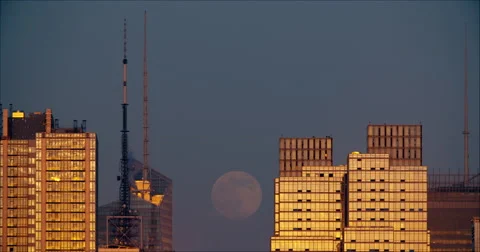 Full moon rising behind reflective glass skyscrapers in New York City Stock Footage 67252828