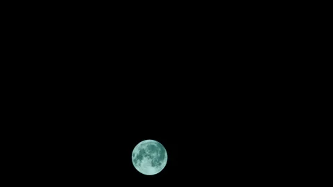 Full moon rising in a clear sky. The moon gradually rises into the black sky 스톡 동영상 245320744