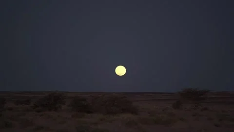 Full Moon Rising Over Dark Desert Landscape at Twilight Stock Footage 335636317