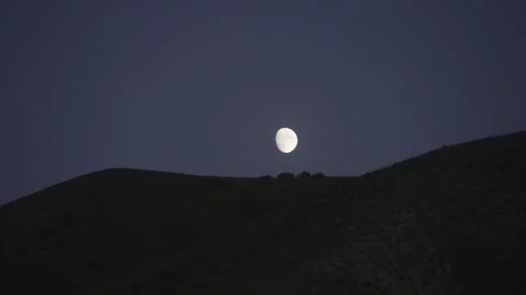 Full moon rising over a dark hill at blue hour, Kyrgyzstan Stock Footage 347243152