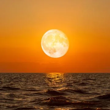 Full moon rising over empty ocean at night Stock Photos