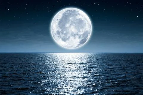 Full moon rising over empty ocean at night with copy space Stock Photos