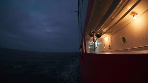 Full moon rising over the ocean with a ship sailing under its glow, creating a Stock Footage 324084353