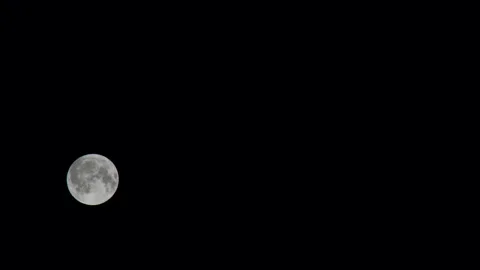 Full moon sets in a clear sky. Moon gradually descends in the black sky 库存影片 245320756
