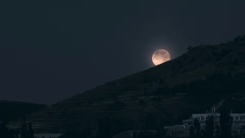 The full moon sets over the mountain at night Stock Footage 126884040