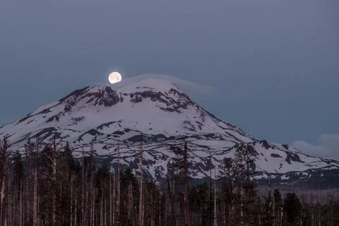 Full Moon Setting Over Snowy Mountain Stock Photos