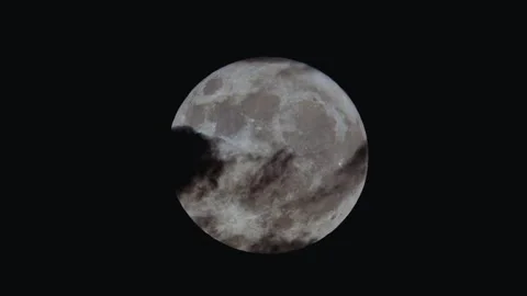 Full moon shining bright behind dark moving clouds in deep black sky. Stock Footage 343999932