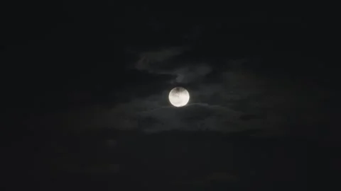 Full moon shining in the night sky surrounded with dark clouds Stock Footage 284455479