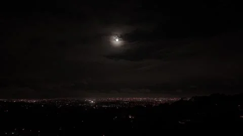A full moon shining over a city in the dark of night Stock Footage 310210520