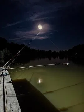 Full moon shining over remote fishing spot at night Stock Photos