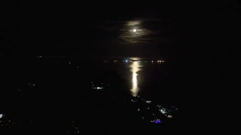 Full moon shining through clouds and reflecting across the calm Pacific Ocean Stock Footage 344225136