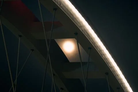 Full moon shining through modern bridge architecture at night, minimalist urban  Stockfoto's