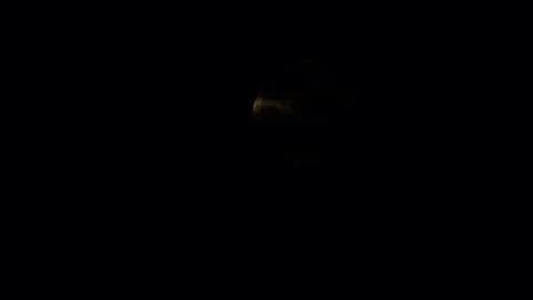 Full moon slowly comes out from behind the black clouds. Close-up. Video stock 246878260
