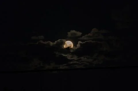 Full moon surrounded by clouds before the eclipse Foto stock