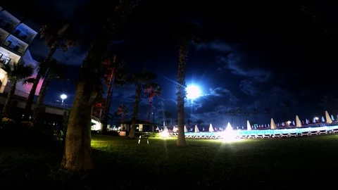 Full Moon Timelapse in Cloudy Wheather with Palm Three & Pool Stock Footage
