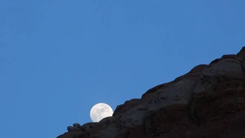 FULL MOON TIMELAPSE RISES OVER DESERT ROCK CLIFF Video stock 80693431