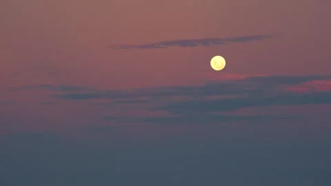 Full moon in vibrant twilight sky with some thin clouds Stock Footage 336034867