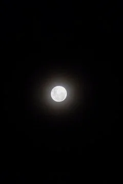 Full moon view isolated in dark black background, in the sky. Stock Photos