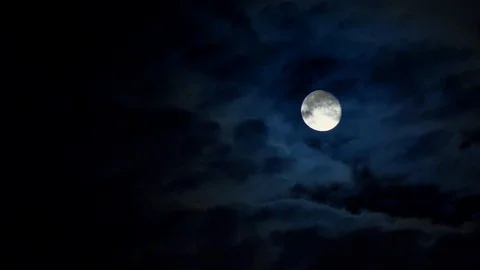 Full moonrise through the clouds on dark blue night sky. 10 second, 30 fps Vidéo 91446558